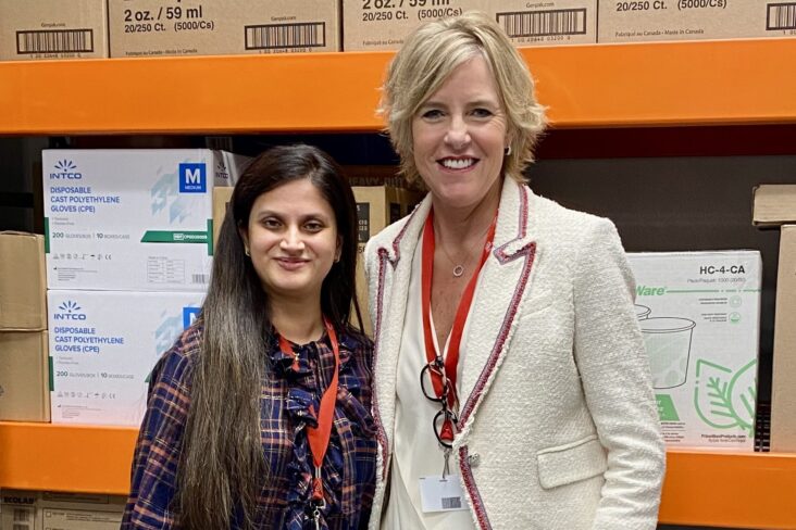 Two females standing in front of bulk food products in a local retailer.