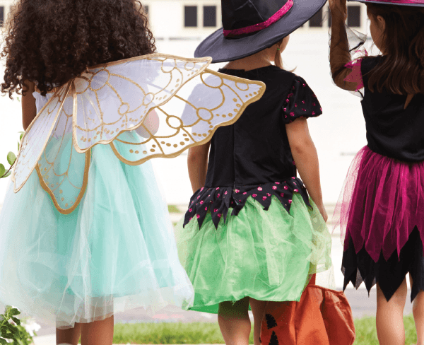 hree children wearing Halloween costumes, ready for trick-or-treating.