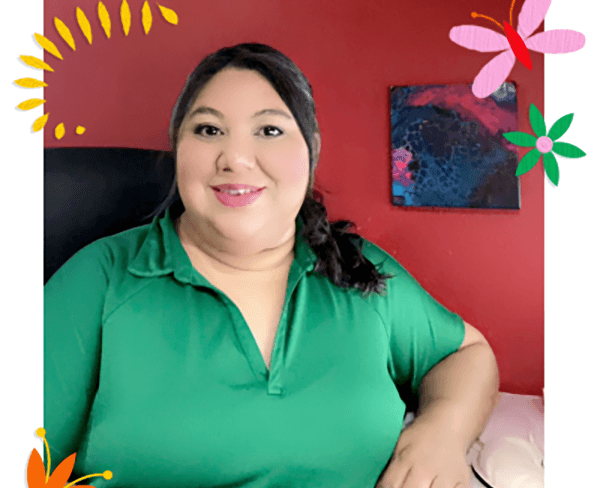 A woman in a green shirt seated against a vibrant backdrop, exuding a captivating aura amidst the colorful surroundings.